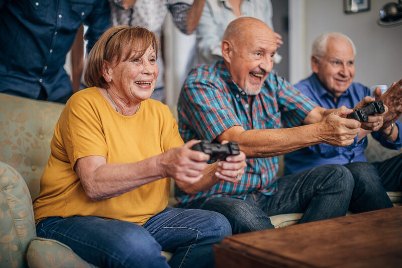 Older adults laughing while playing a video game